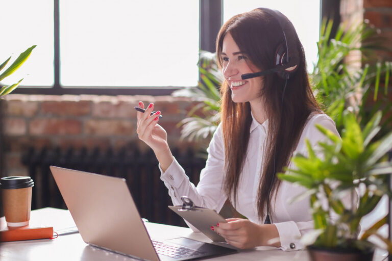 femme souriante avec un téléphone dans un bureau